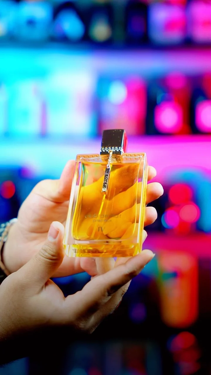بطری عطر زرد در دست